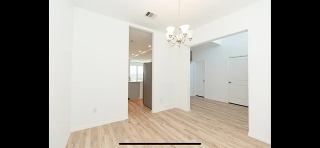 a view of a bedroom with wooden floor and a window