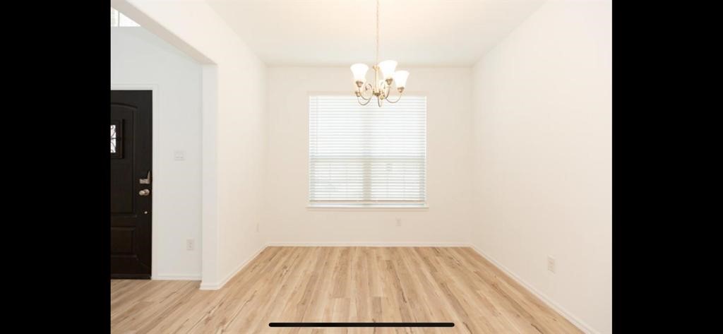 19044 Pinewood Grove Trail New Caney, TX 77357 - Photo 6 of 24 a view of a bedroom with wooden floor and a window