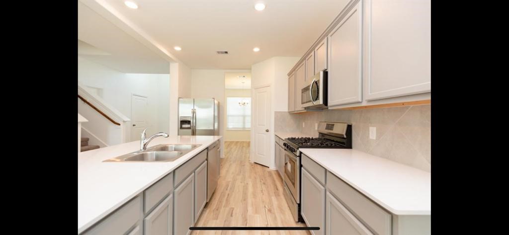 19044 Pinewood Grove Trail New Caney, TX 77357 - Photo 7 of 24 a kitchen with a sink stove and cabinets