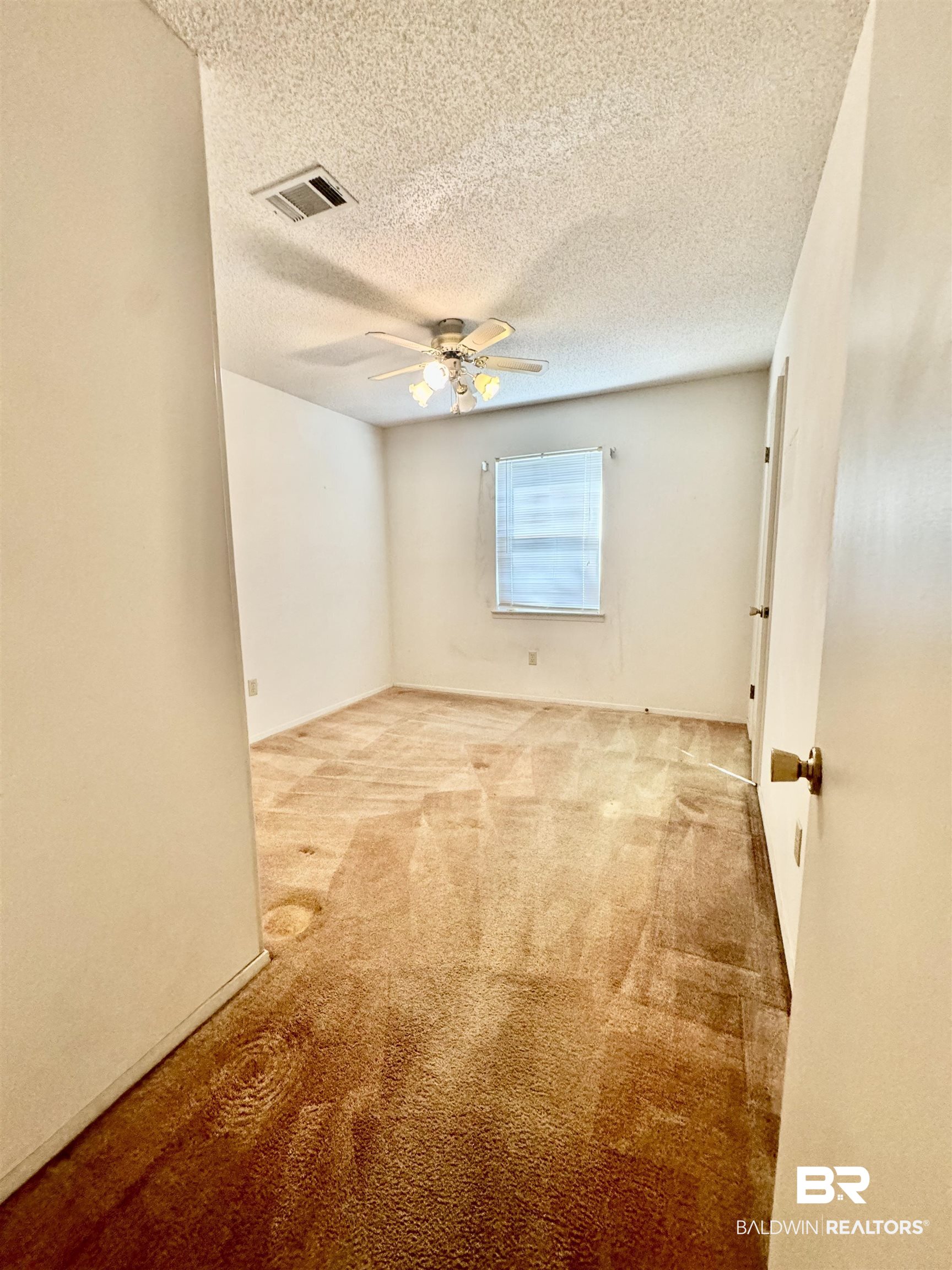512 Deborah Court Foley, AL 36535 - Photo 19 of 23 Spare room featuring ceiling fan, light colored carpet, and a textured ceiling
