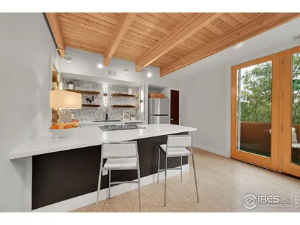 a open kitchen with stainless steel appliances kitchen island granite countertop a table chairs in it and a window