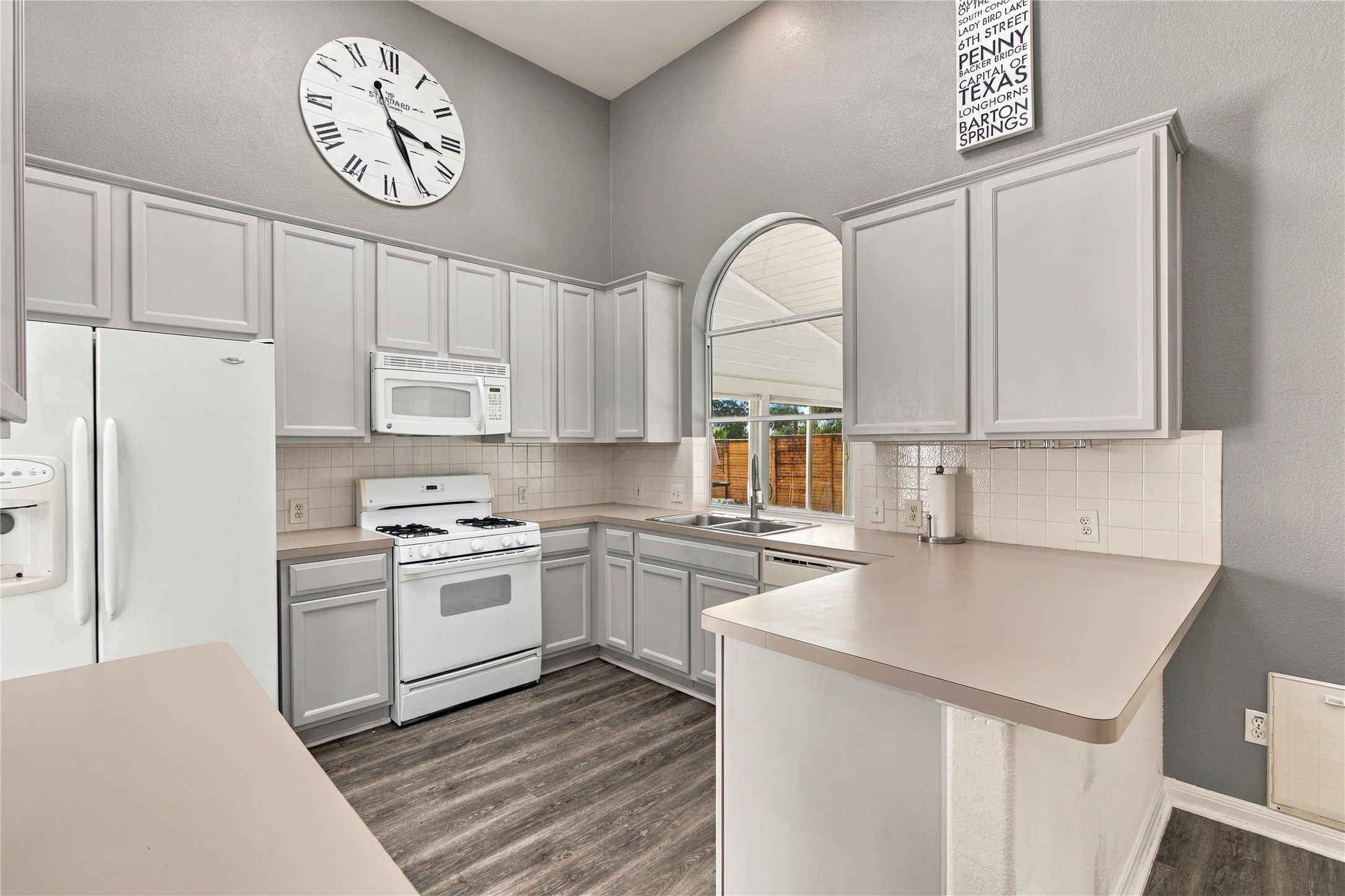910 Point Run Drive Pflugerville, TX 78660 - Photo 13 of 39 High ceilings and a large arched window enhance this functional kitchen workspace.