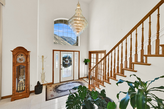 1085 Windsor Drive Provo, UT 84604 - Photo 15 of 83 Foyer featuring a towering ceiling, stairs, tile patterned flooring, and a chandelier
