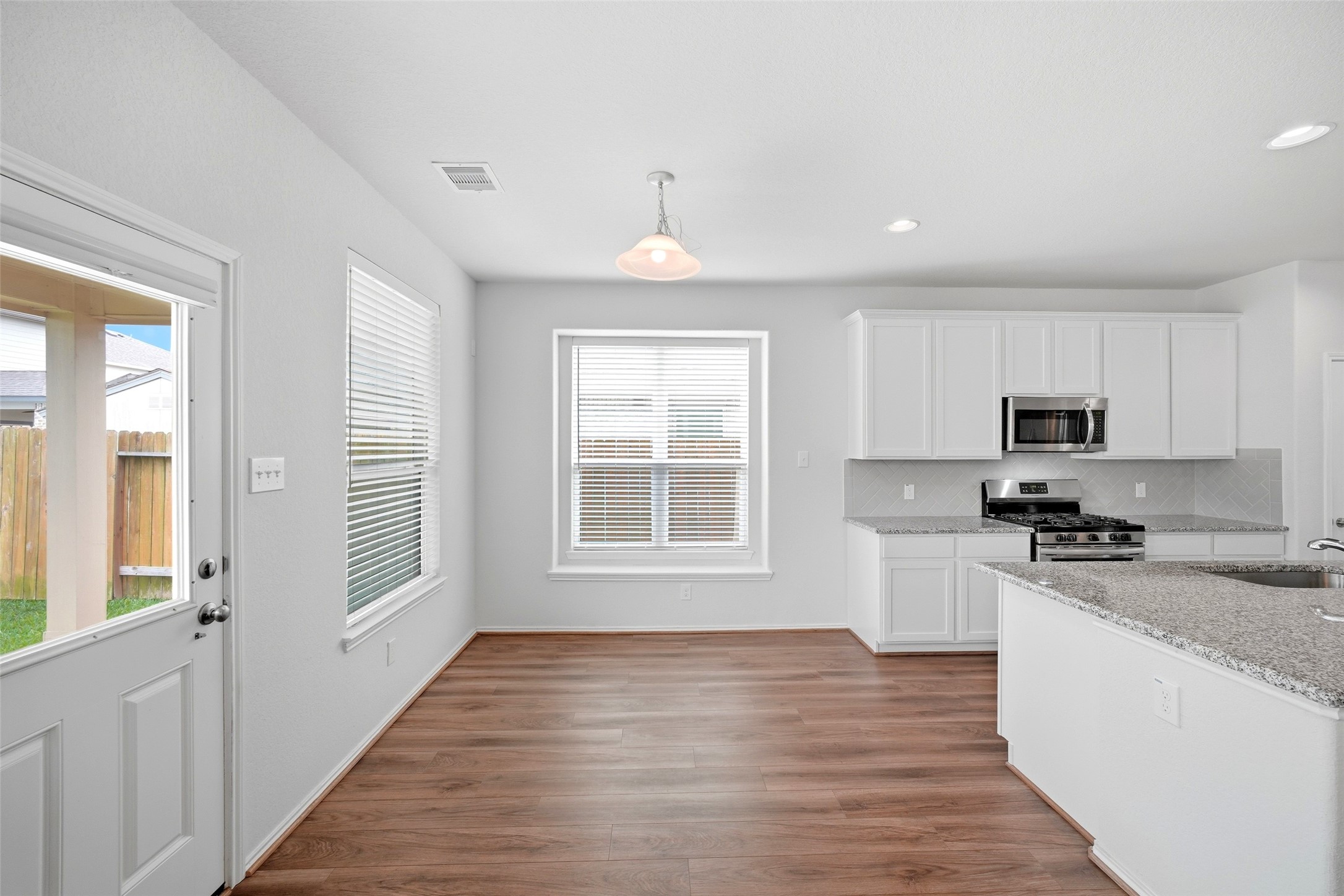 5309 Camerford Court Alvin, TX 77511 - Photo 14 of 29 a kitchen with stainless steel appliances granite countertop a stove a sink a refrigerator white cabinets and wooden floor