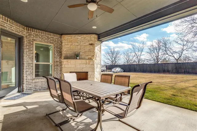a view of an empty room with wooden floor and a ceiling fan