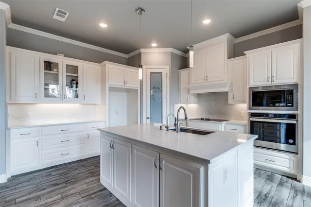 a kitchen with granite countertop a sink stainless steel appliances and cabinets