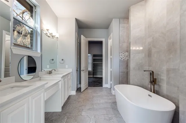 a spacious bathroom with a tub sink and mirror