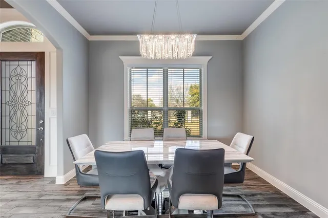 a view of a dining room with furniture a chandelier and wooden floor
