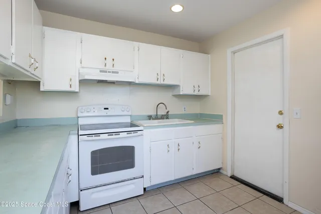 a kitchen with white cabinets and white appliances