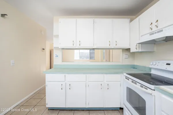a kitchen with white cabinets and white appliances