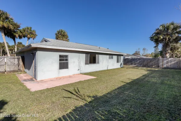 a front view of house with yard and trees in the background