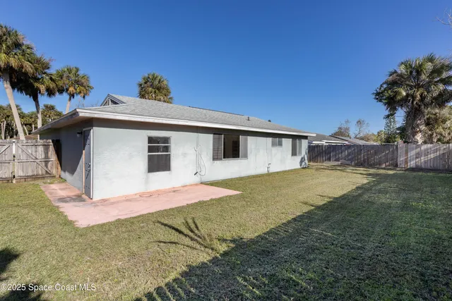 a front view of house with yard and trees in the background