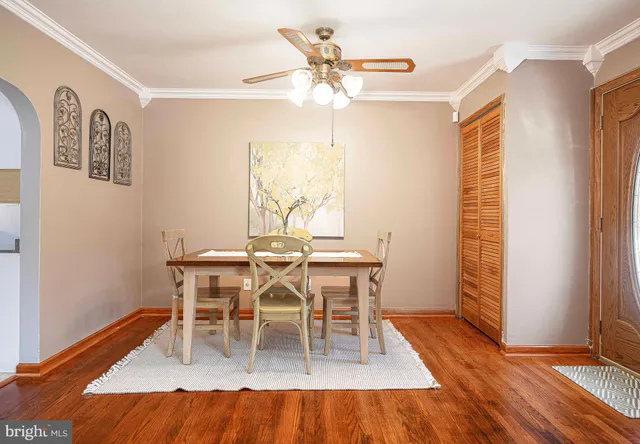 a dining room with furniture a chandelier and wooden floor