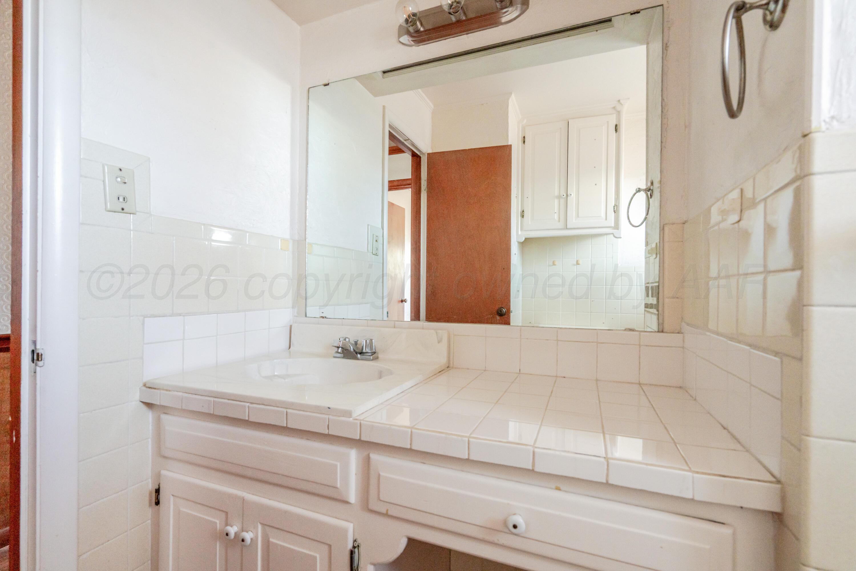 3308 Sunlite Street Amarillo, TX 79106 - Photo 20 of 37 a bathroom with a sink and a mirror