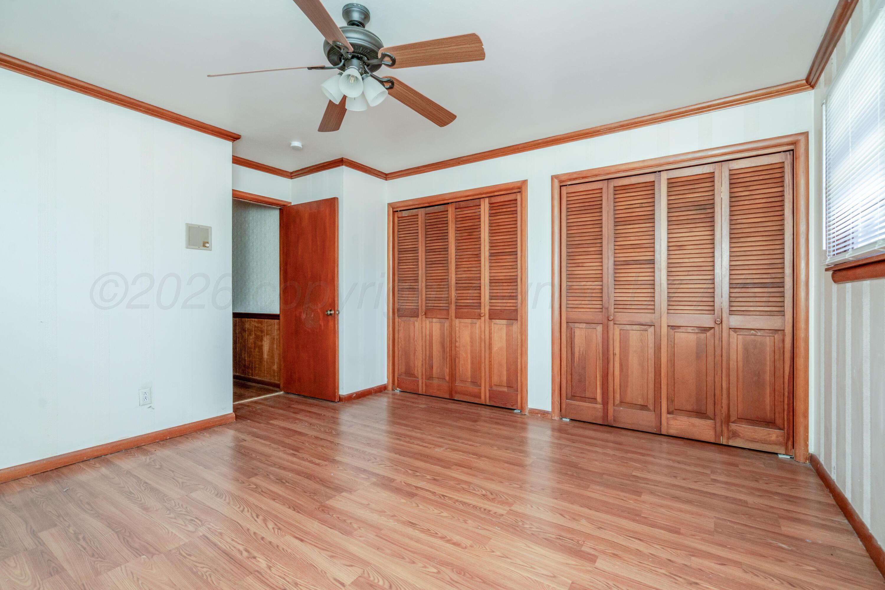 3308 Sunlite Street Amarillo, TX 79106 - Photo 27 of 37 an empty room with wooden floor chandelier fan and windows