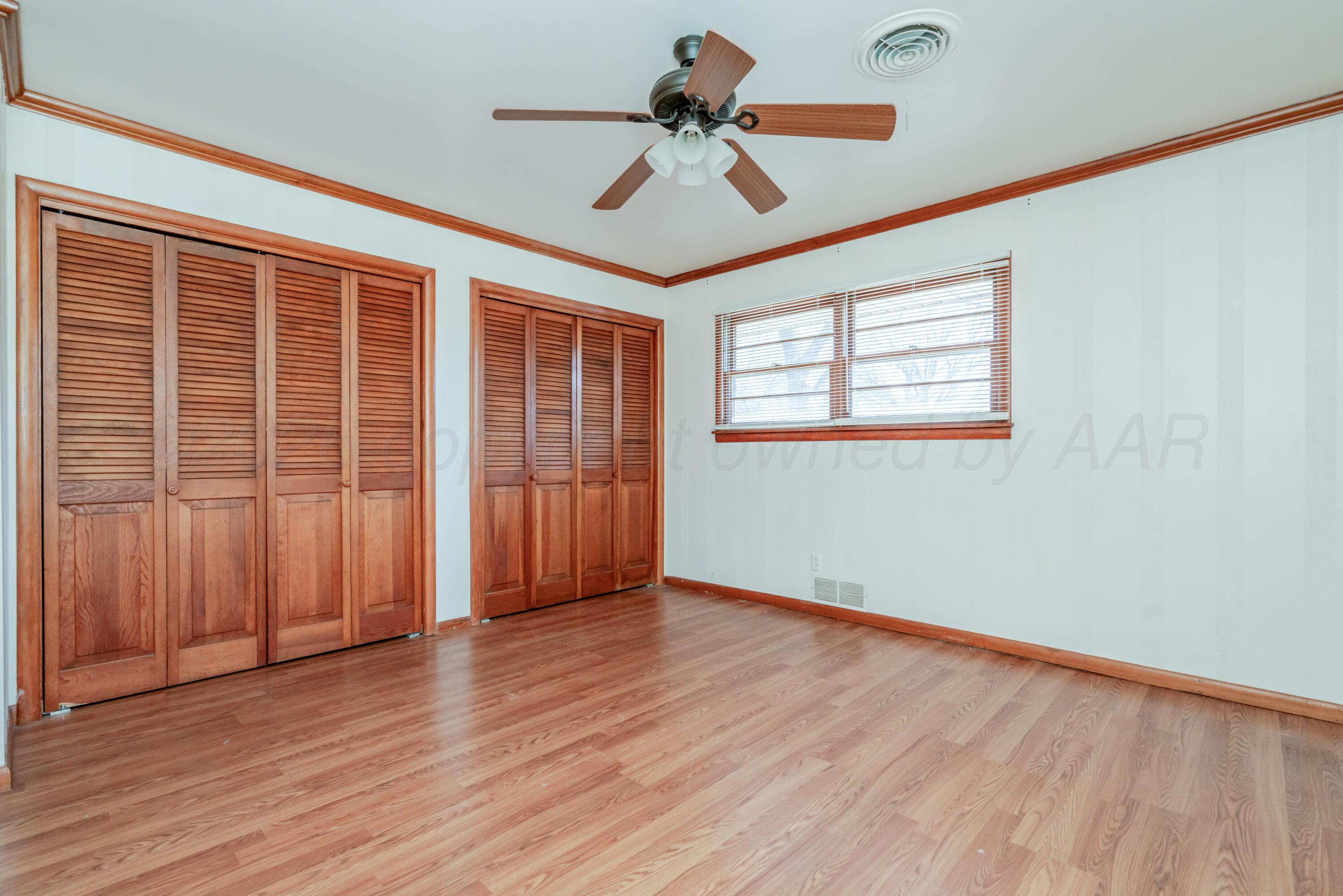 3308 Sunlite Street Amarillo, TX 79106 - Photo 28 of 37 an empty room with wooden floor chandelier fan and windows