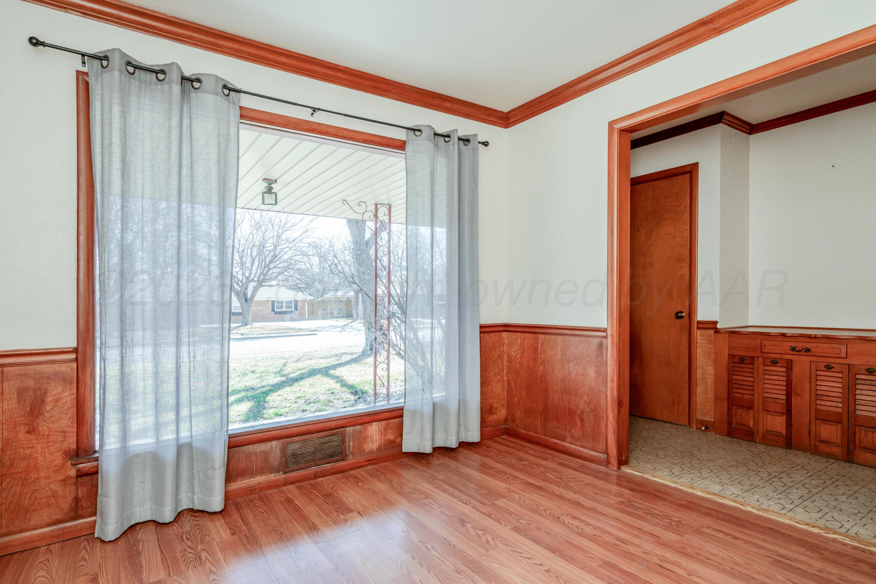 3308 Sunlite Street Amarillo, TX 79106 - Photo 5 of 37 a view of an empty room with wooden floor and a window