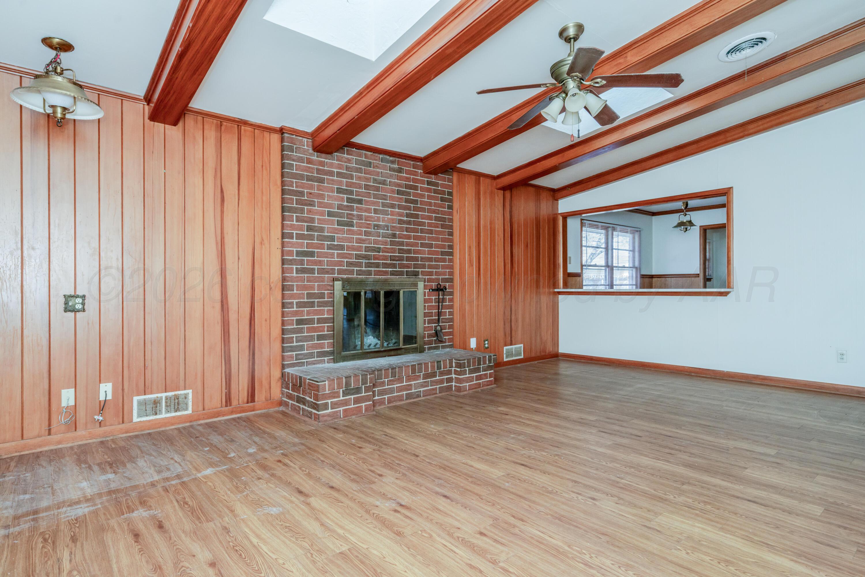 3308 Sunlite Street Amarillo, TX 79106 - Photo 9 of 37 an empty room with wooden floor fireplace and windows