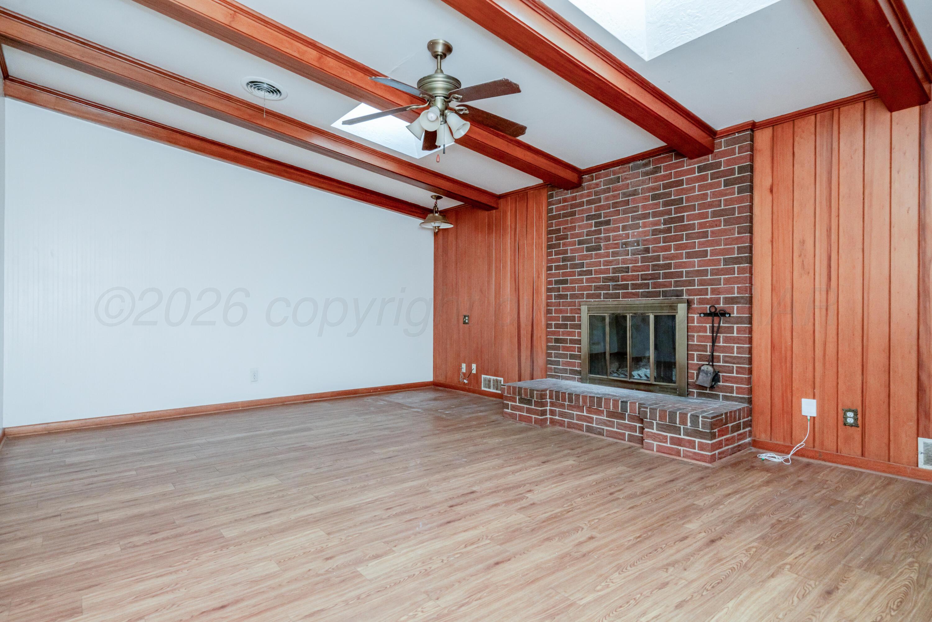 3308 Sunlite Street Amarillo, TX 79106 - Photo 10 of 37 an empty room with wooden floor fireplace and windows