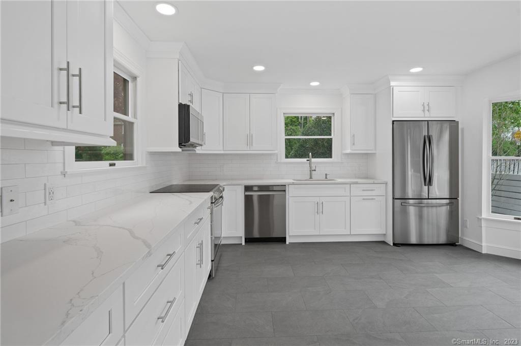 a kitchen with white cabinets and white stainless steel appliances