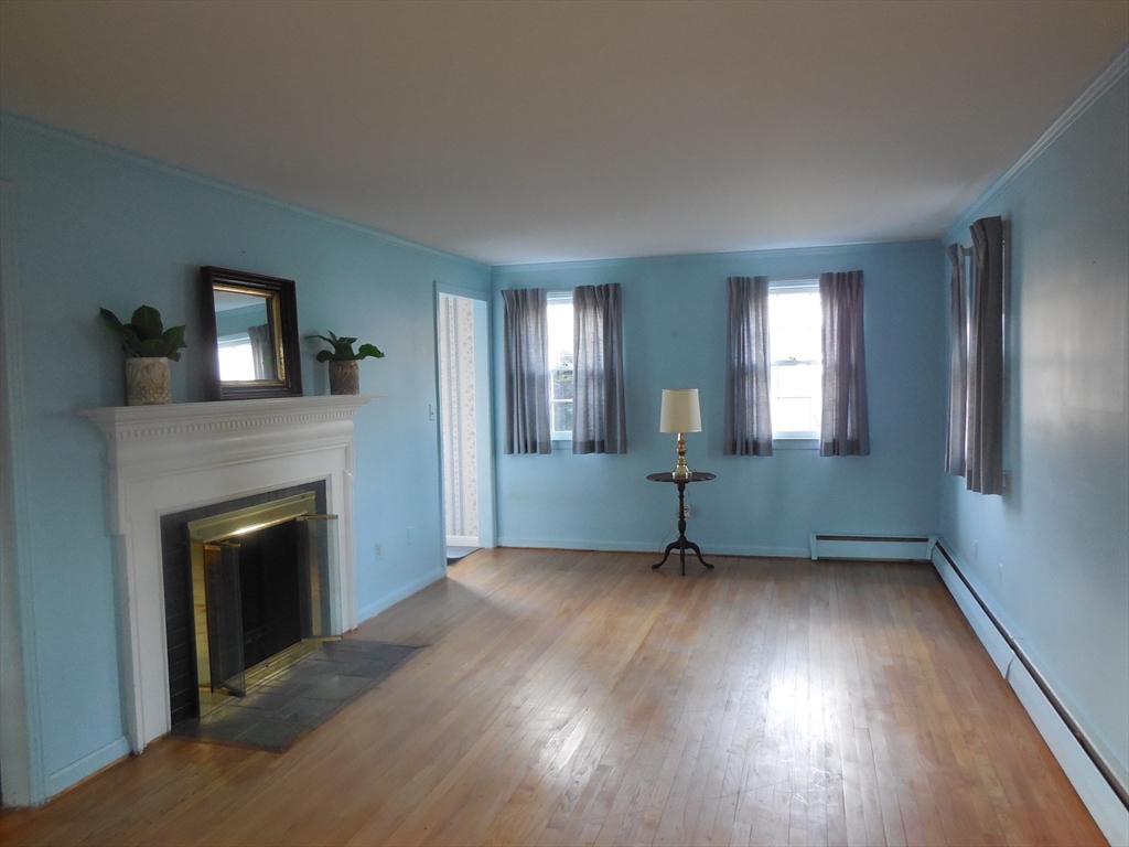 108 West Meadowview Road Holyoke, MA 01040 - Photo 3 of 18 an empty room with windows and a fireplace