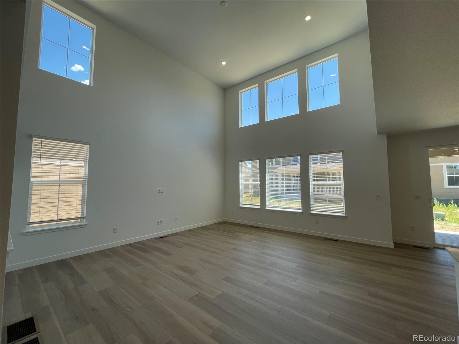 4598 Windmill Drive Brighton, CO 80601 - Photo 4 of 21 an empty room with wooden floor and windows
