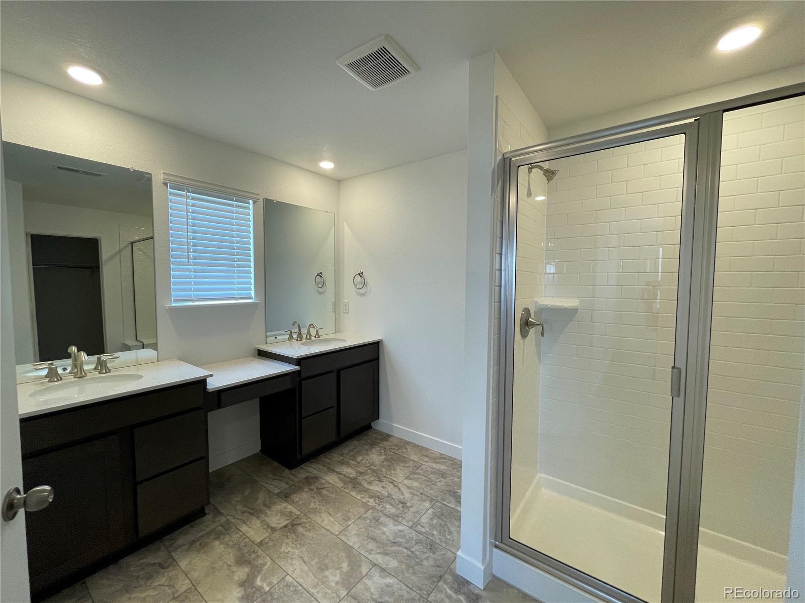 4598 Windmill Drive Brighton, CO 80601 - Photo 8 of 21 a bathroom with a double vanity sink mirror and shower