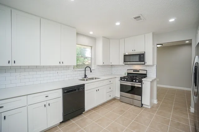 a kitchen with appliances a sink and cabinets
