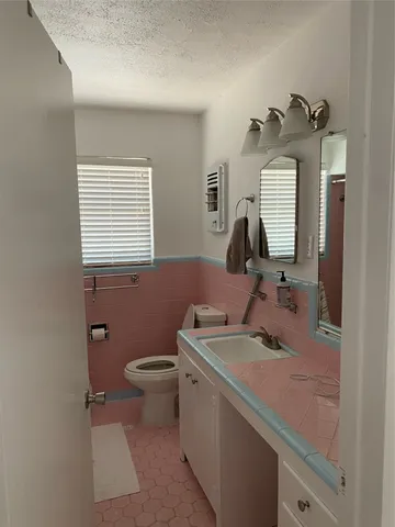 a bathroom with a sink toilet and mirror