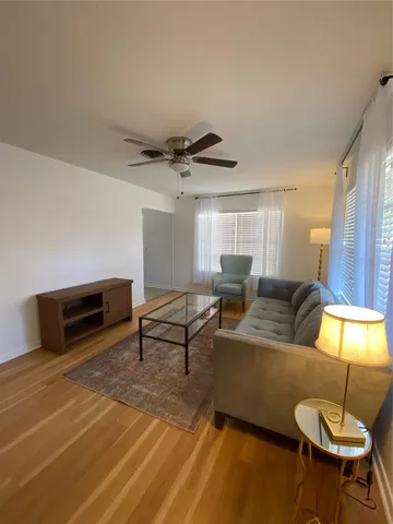 a living room with furniture a ceiling fan and a rug