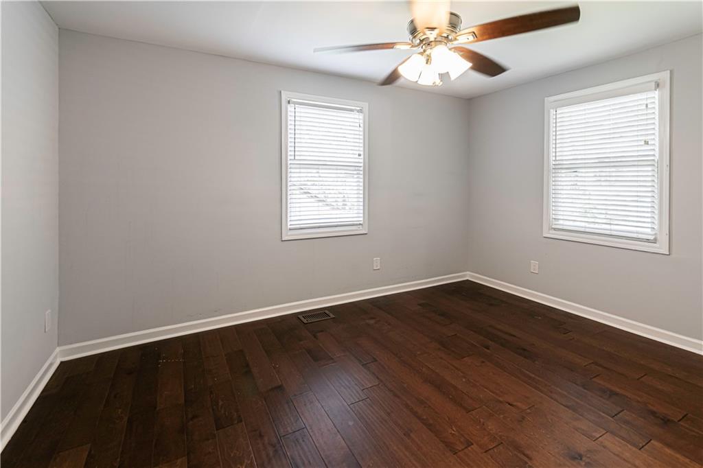 1892 Terry Mill Road Southeast Atlanta, GA 30316 - Photo 13 of 25 an empty room with wooden floor fan and windows