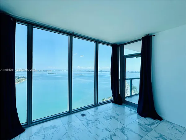 an empty room with floor to ceiling windows and closet