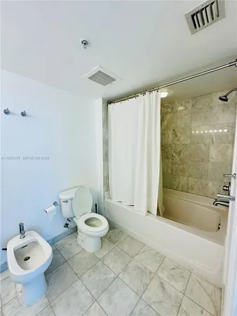 a bathroom with a granite countertop toilet a sink and a shower