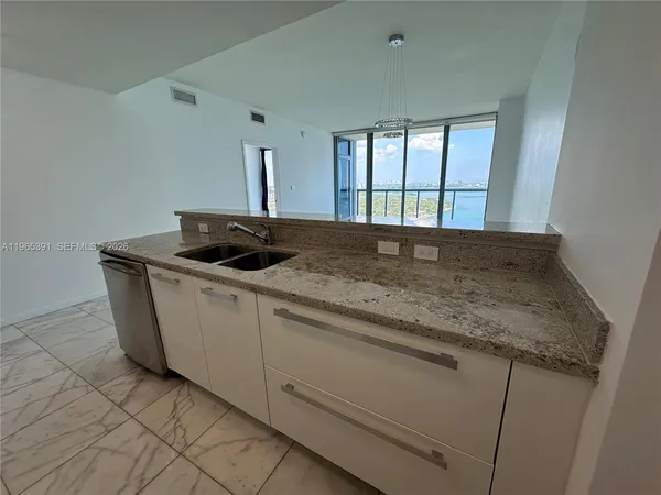a kitchen with granite countertop sink and window