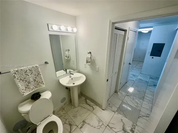 a bathroom with a sink mirror and toilet