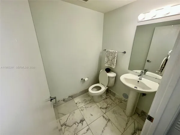 a bathroom with a sink mirror and toilet