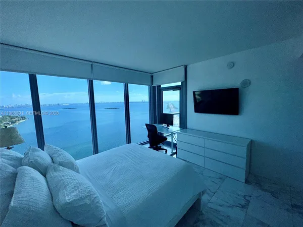 a living room with furniture tv and a floor to ceiling window