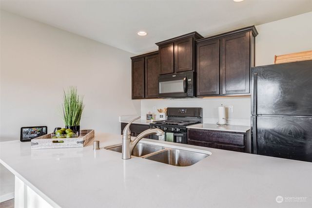 a kitchen with a sink appliances and cabinets