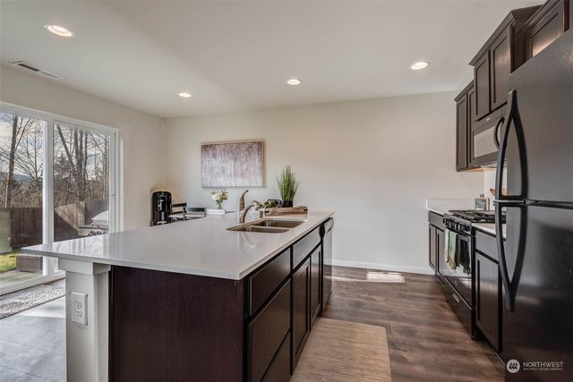 a kitchen with stainless steel appliances granite countertop a stove a refrigerator and a sink