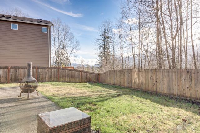 a view of a backyard with wooden fence