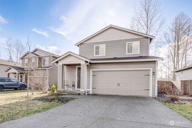 a view of a white house with large windows next to a road