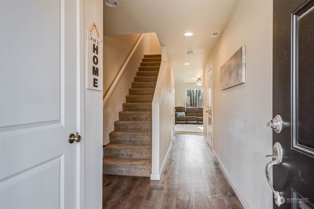a view of a hallway with wooden floor and staircase