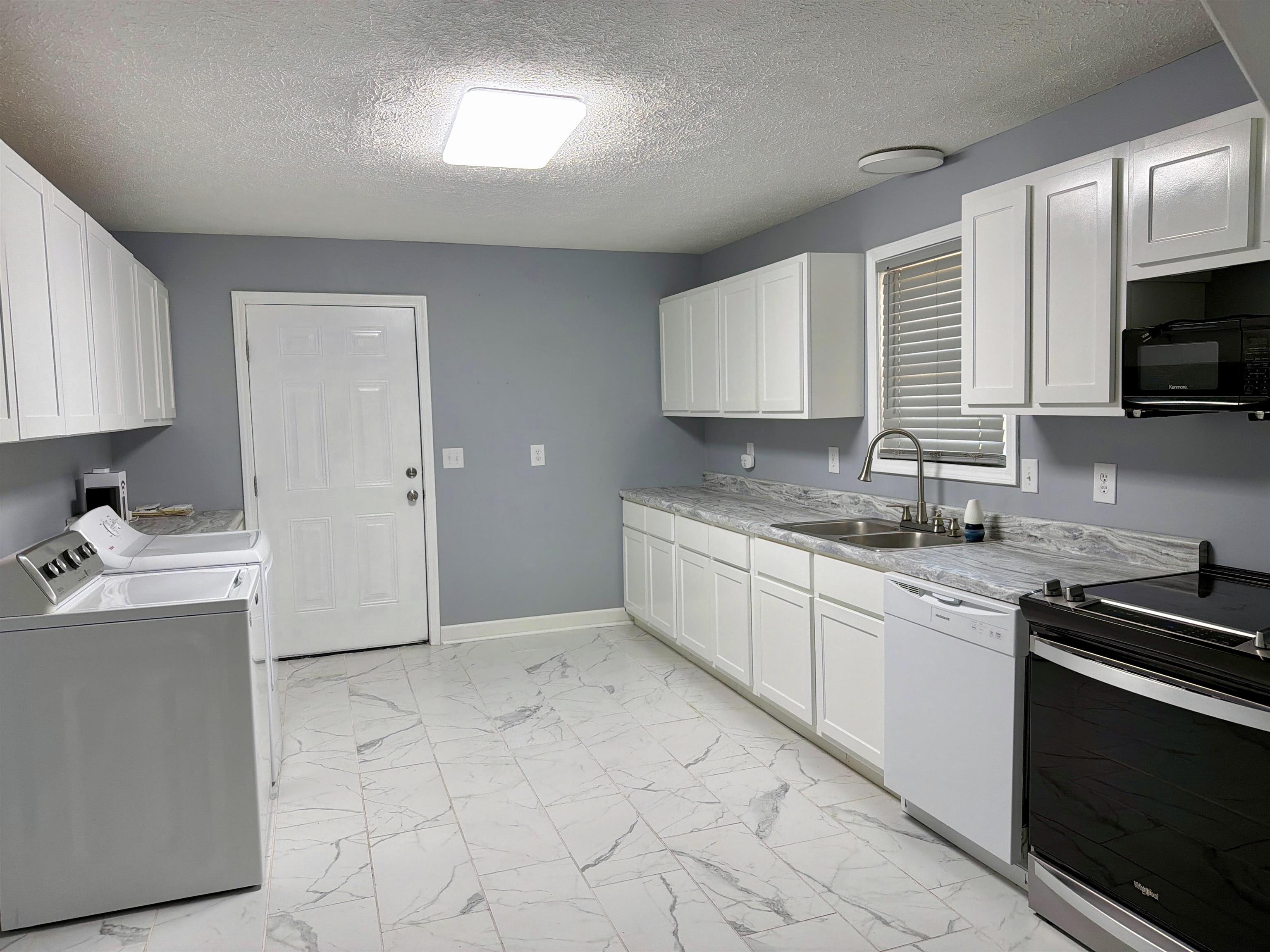 8022 45th Highway Ramer, TN 38367 - Photo 5 of 21 White shaker-style cabinetry, patterned countertops, and tile flooring
