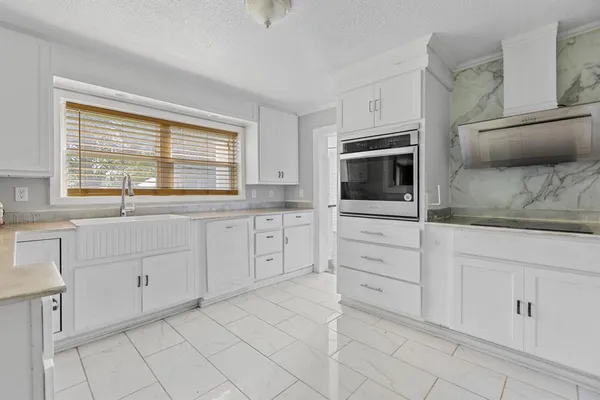 a kitchen with granite countertop white cabinets and stainless steel appliances