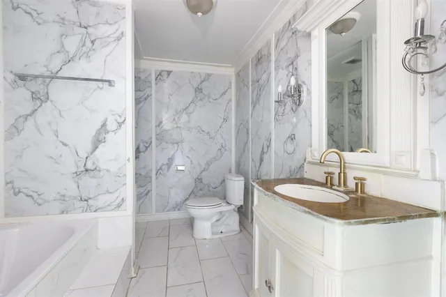 a bathroom with a granite countertop sink a toilet and shower