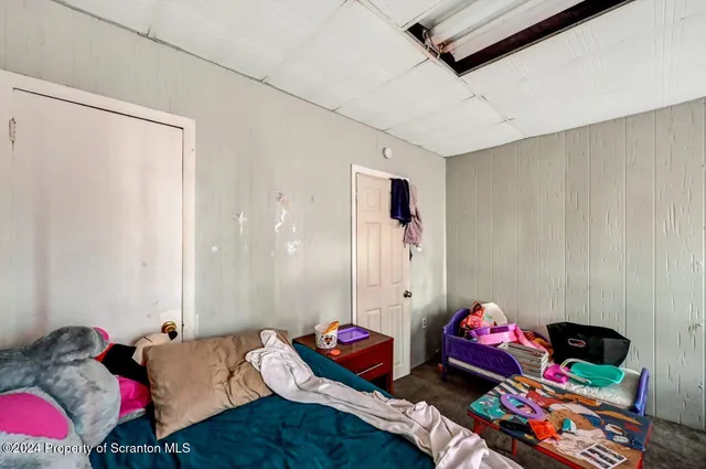 a bedroom with furniture and a flat screen tv
