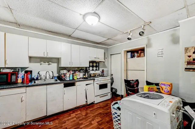a kitchen that has a lot of cabinets a sink and appliances in it