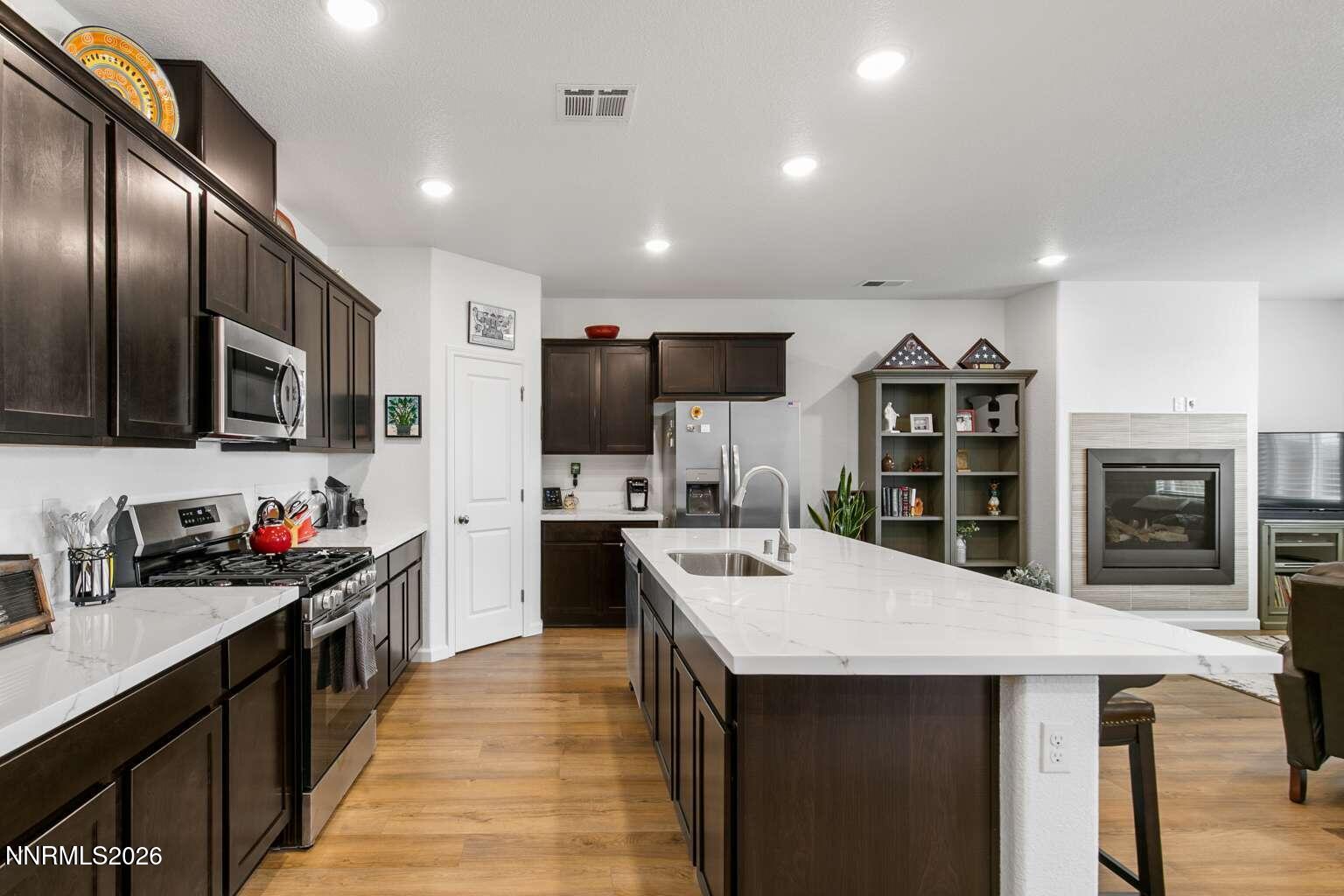 3274 Eleanor Way Fernley, NV 89408 - Photo 3 of 17 a kitchen with stainless steel appliances a sink stove refrigerator and cabinets