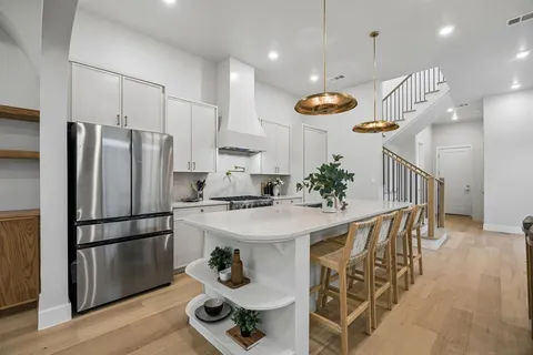 a kitchen with stainless steel appliances granite countertop a sink a stove and a refrigerator