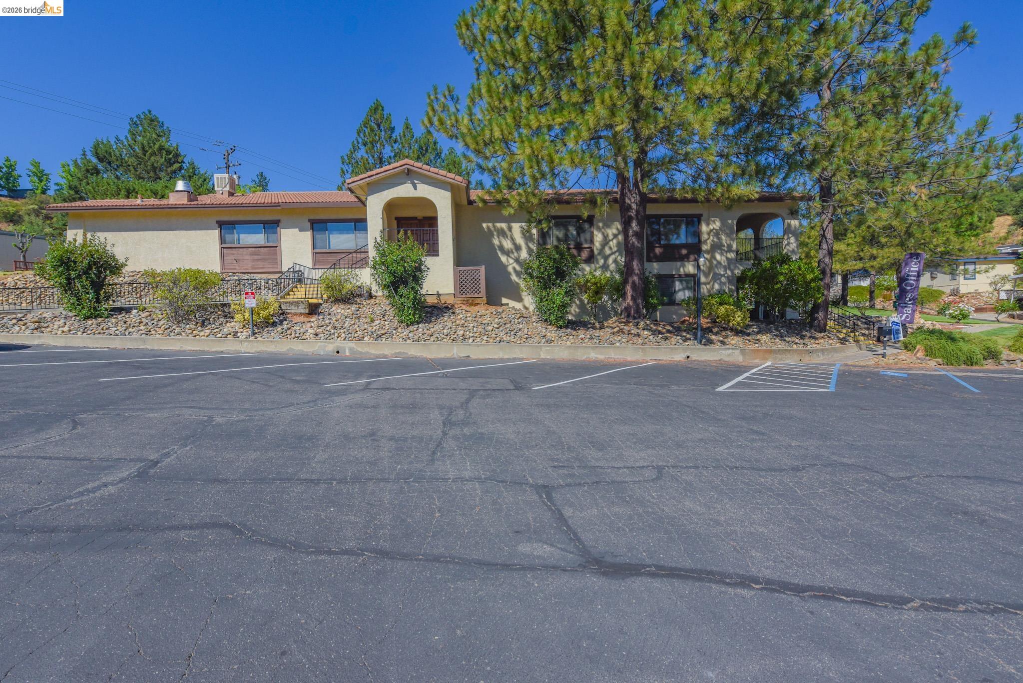 18717 Mill Villa Road, Unit 235 Jamestown, CA 95327 - Photo 18 of 26 View of front of home featuring uncovered parking, stucco siding, and a chimney